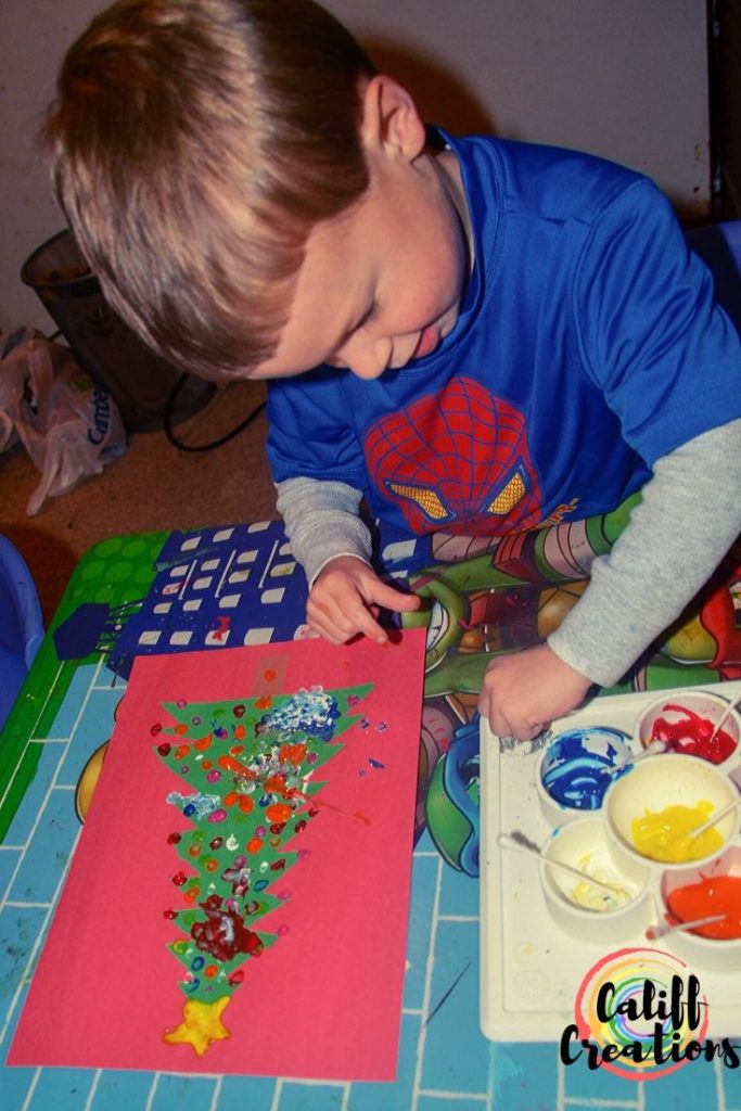 Adding glitter to his Christmas Craft
