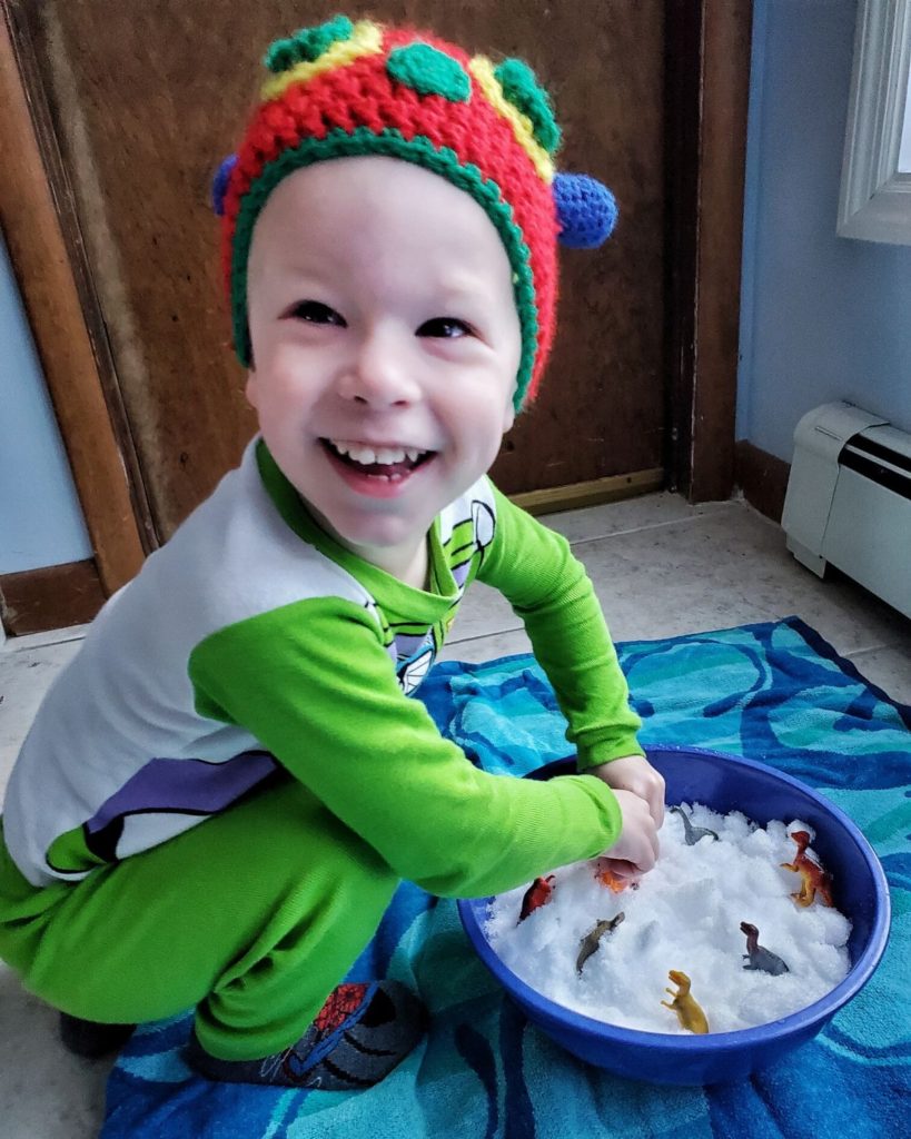 A happy 4 year old with sensory bin