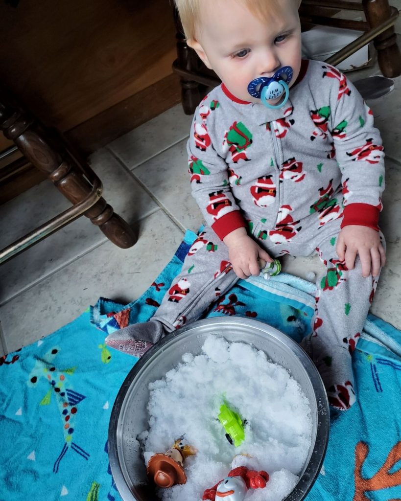 An Unimpressed 1 year old with sensory bin