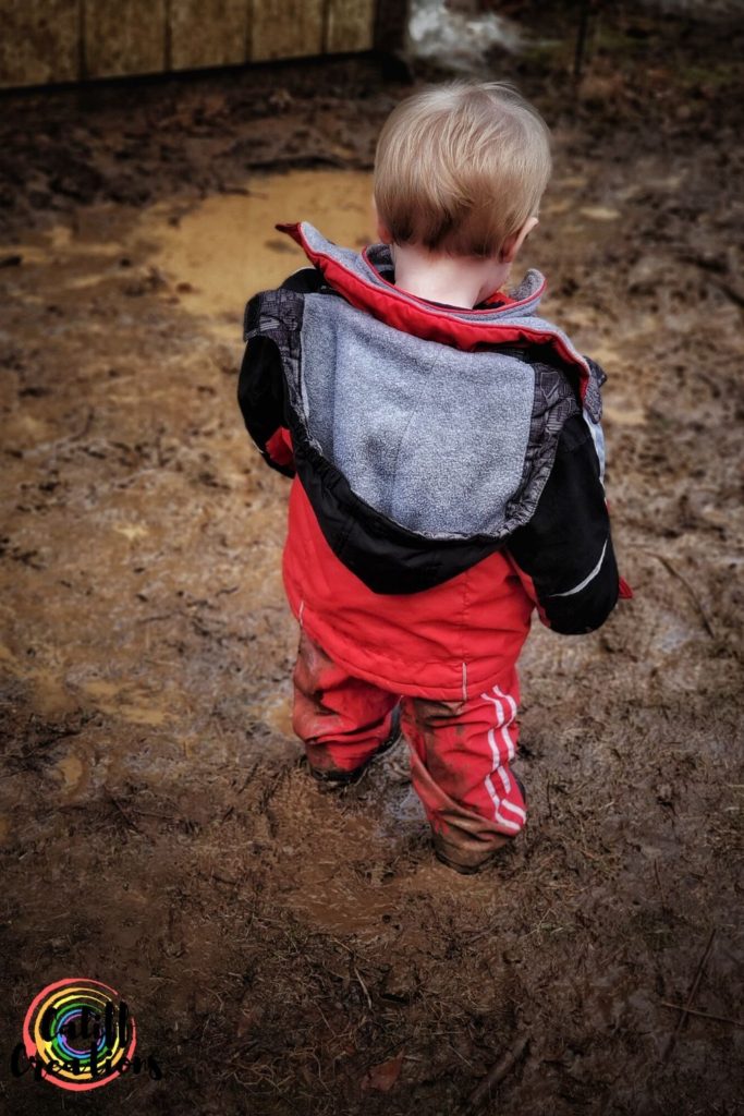 My toddler walking in the mud outside, logging hours toward our goals