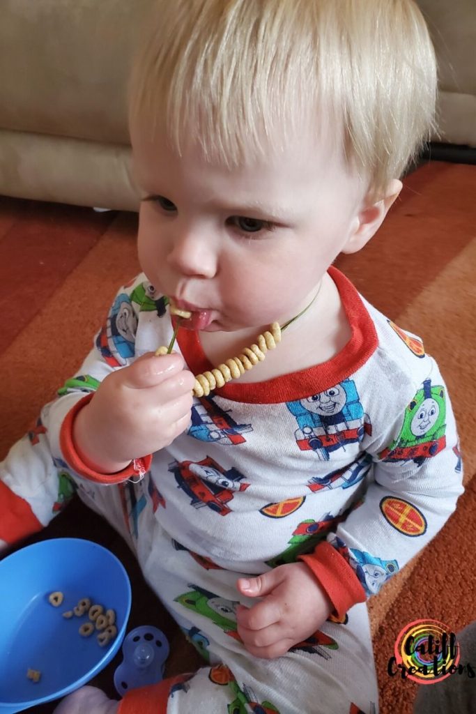 Eating his Cheerio necklace at home