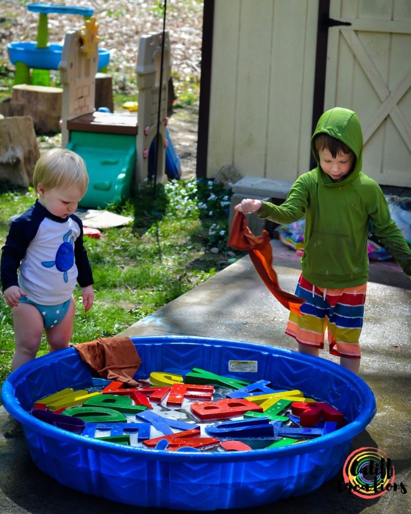 My boys getting ready to wash the alphabet outside
