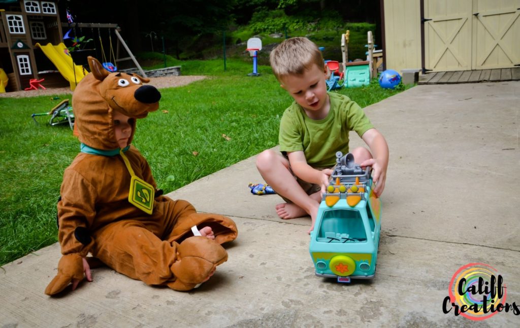 Boys dressed as Shaggy and Scooby and playing with their gifted Mystery Machine