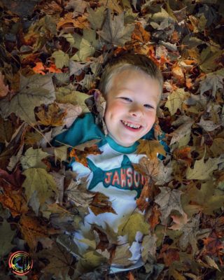 all smiles during fall play with leaves