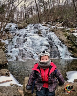 My son by a frozen waterfall