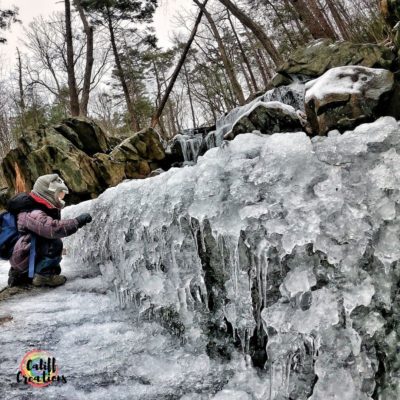 My son exploring a frozen waterfall 